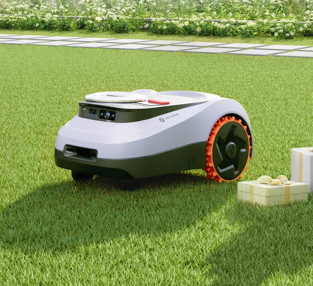 Un robot tondeuse Segway Navimow i sur une pelouse verte.