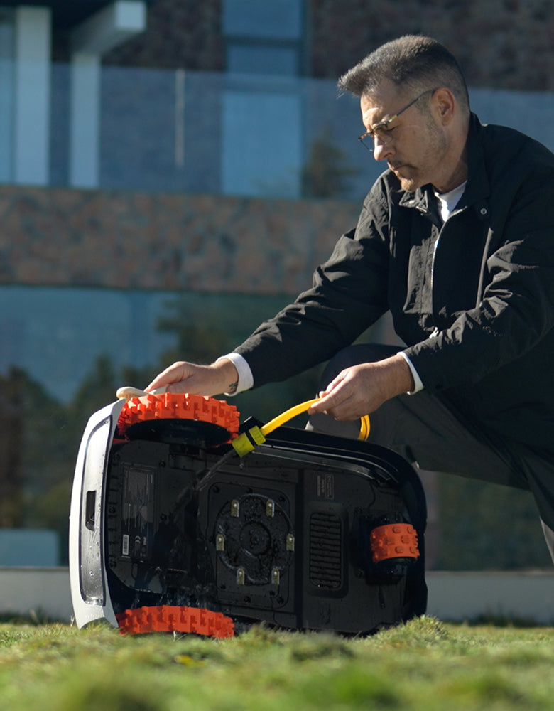 Navimow i105E tondeuse robot est nettoyée par un homme barbu.