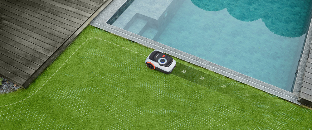 Navimow i105E tondeuse robot tondant la pelouse devant la piscine.